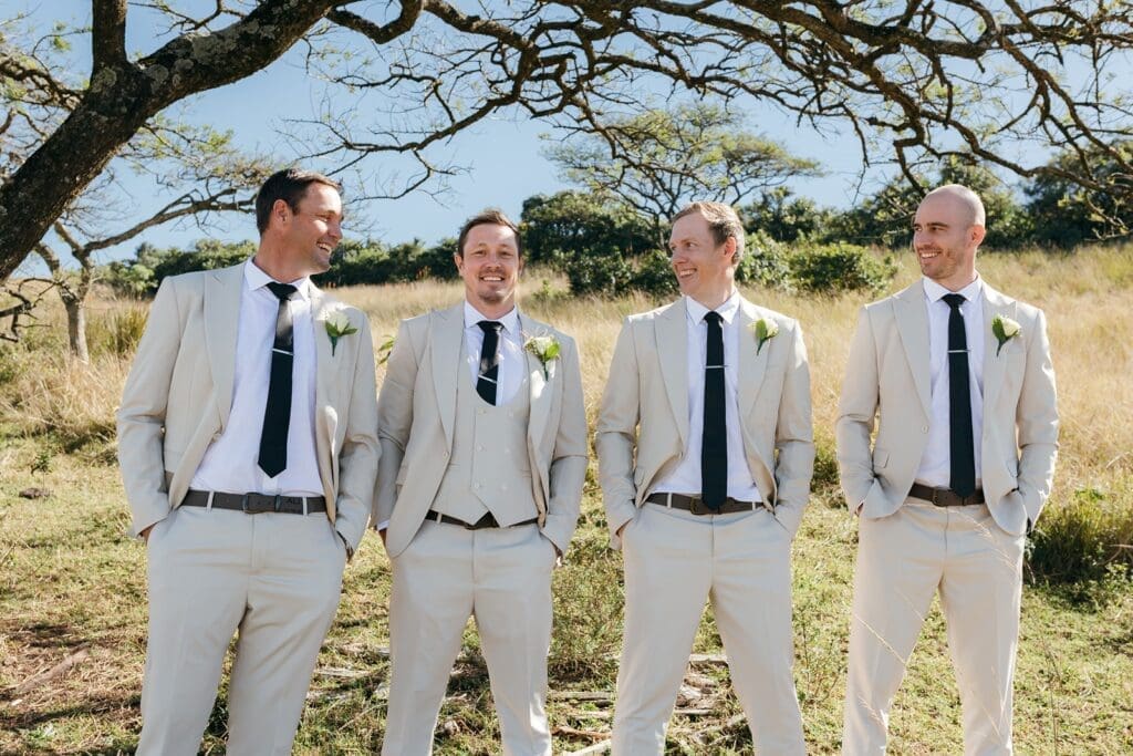 Groom and groomsmen standing together in the bush
