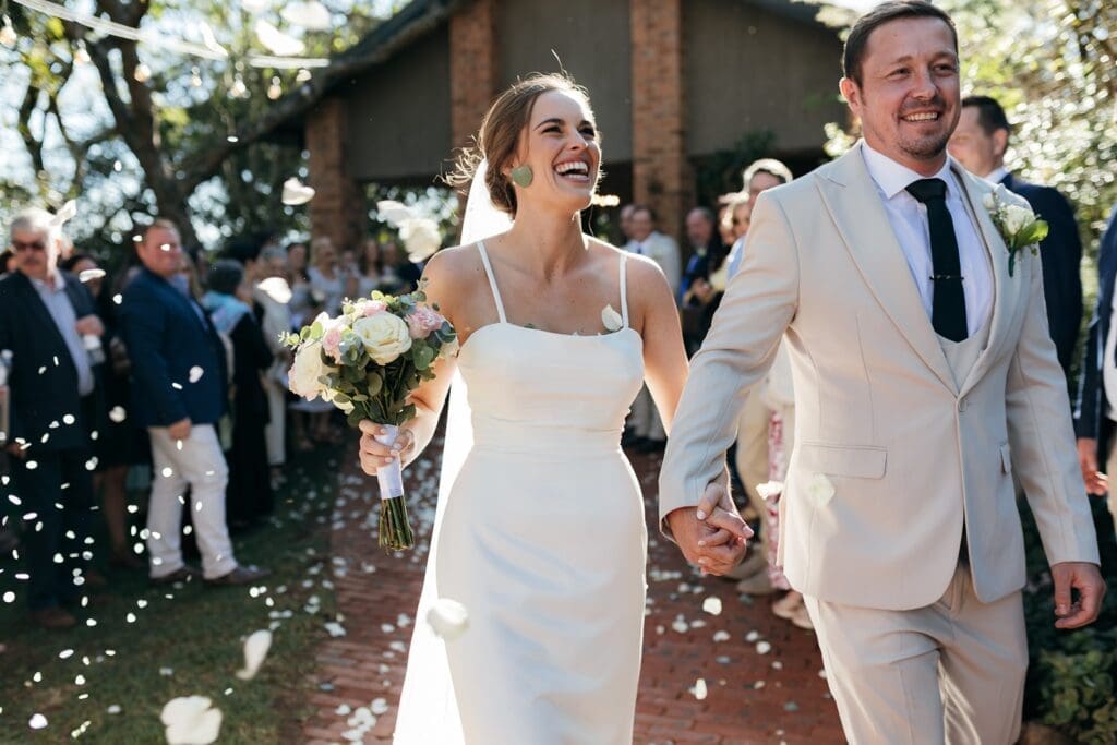 Bride and groom exiting the chapel with confetti toss at The Hilton Bush Lodge