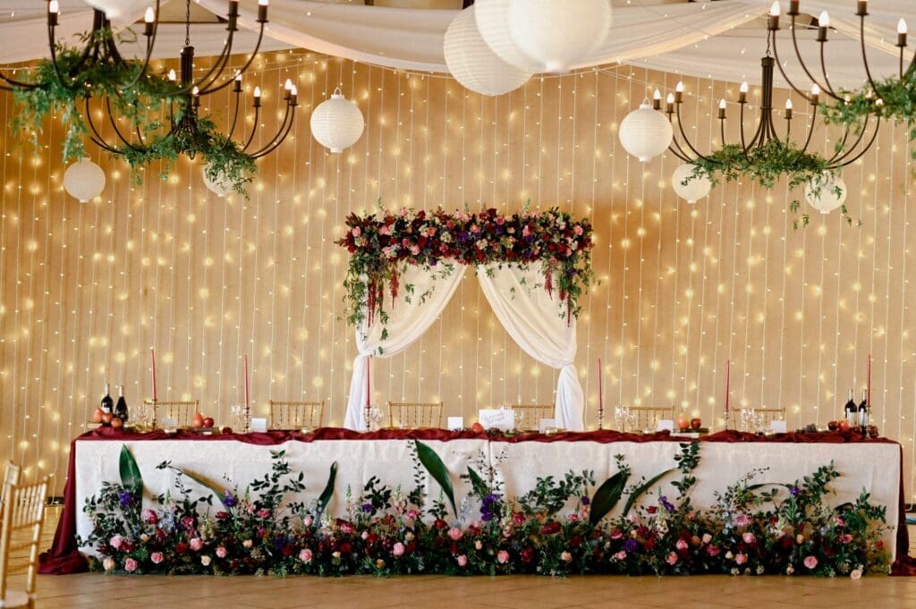 Bridal main table in wedding reception venue with fairy light backdrop