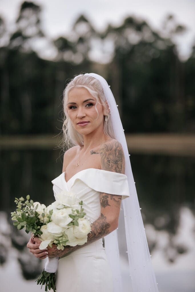 Bride standing with bouquet with makeup done by Blush Pro Make-Up