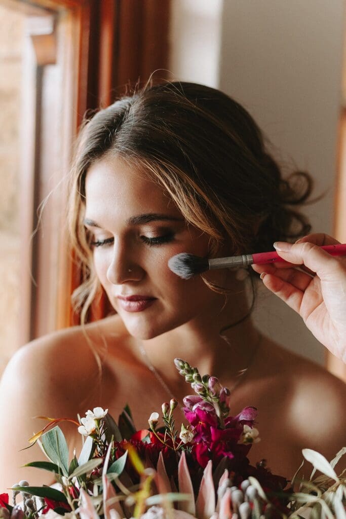 Close up of makeup brush on bride's cheek showing elegant makeup from Blush Make-Up