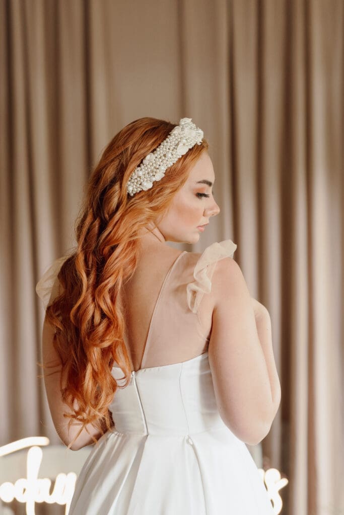 Bride wearing thick pearl custom made headband, back facing camera