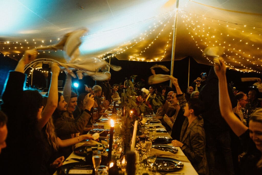 Wedding guests twirling serviettes above their heads in celebration.