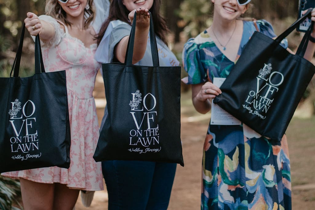 Guests at Love on the Lawn showing off their black goodie bags.