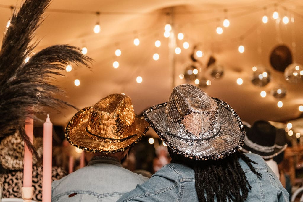 View from the back of 2 guests wearing glitter cowgirl hats