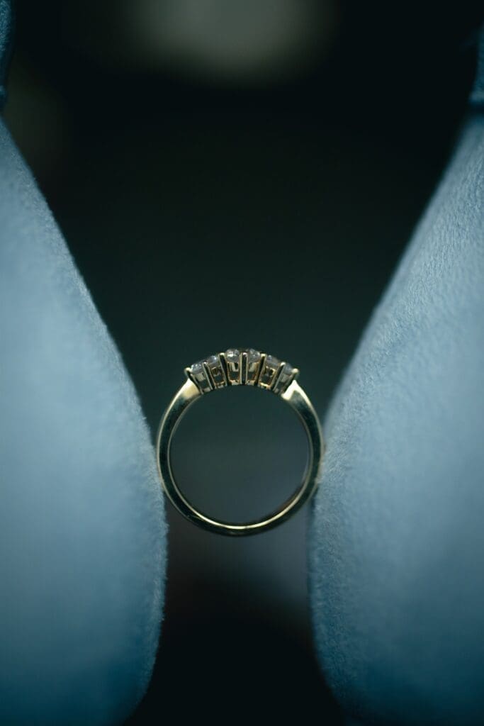 Details image of wedding ring perfectly balanced between bride's heels