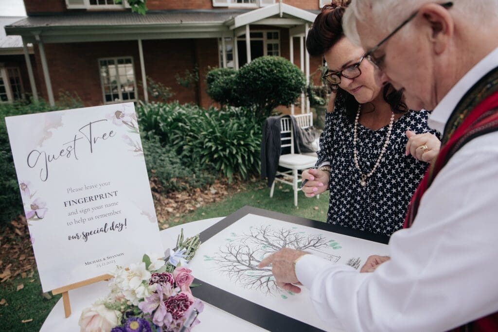 Wedding guests adding their fingerprints to the creative and interactive guest book by Fingerprint Trees.