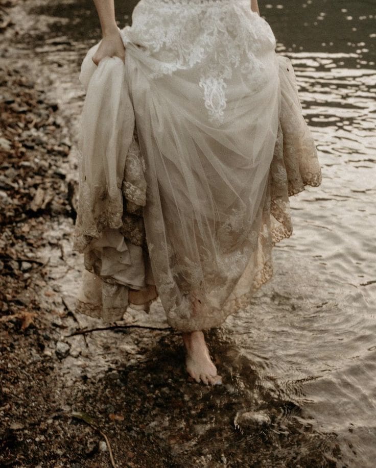 Bride walking barefoot through mud and water